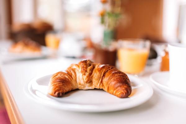 A croissant sits on a plate A croissant sits on a plate
