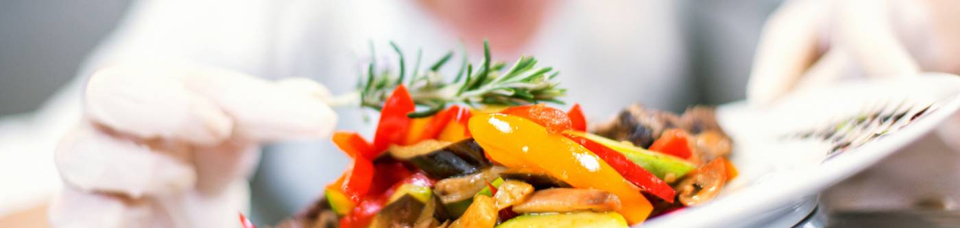 A chef finishes plating a dish